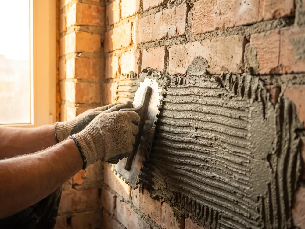 Mineralischer Kleber wird auf die Wand aufgezogen