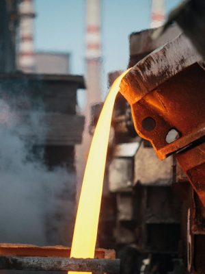 Close-up of molten metal pouring in a foundry, showcasing industrial processes.